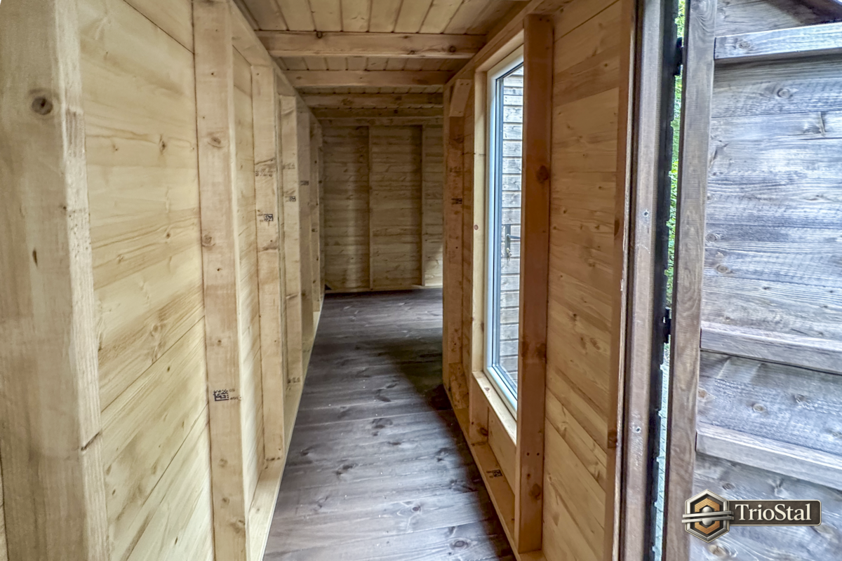Wnętrze domku ogrodowego BoxHouse w Warszawie – drewniana konstrukcja, podłoga i okno